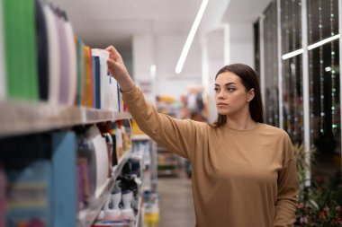 Markette tramvaylı ve uzun saçlı beyaz bir bayan şampuanı seçiyor. Bir kadın yerel bir organik mağazadan yiyecek ve temel ürünler alır. Boşluğu kopyala.