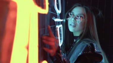 Gözlüklü güzel bir genç bayanın portresi, kameraya bak. Bir partide neon renkli pozlar veren kendine güvenen ve zarif bir kadın. Güzel kadın, kapat..