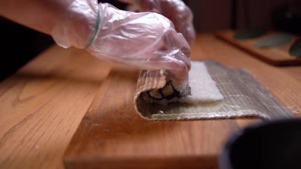 Готуйтеся руками, коли готуєте японський суші. Японський шеф-кухар на роботі готує смачний суші-рол. Смачна японська їжа. — стокове відео