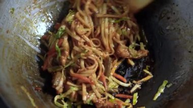 Zeytin yağında pişirilmiş tavadaki eriştelerin yakın çekimi. Tahta spatula karıştırın 4k