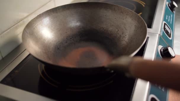 Il cuoco versa l'olio di girasole in una padella, vista dall'alto. La padella è sul fornello, e l'olio per friggere è versato in esso. — Video Stock