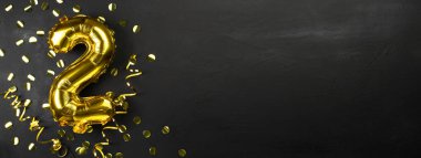 İki ya da iki numaralı altın folyo balonu. Üzerinde ikinci siyah beton yazı olan doğum günü tebrik kartı. Yıldönümünü kutluyoruz. Pankart. Boşluğu kopyala