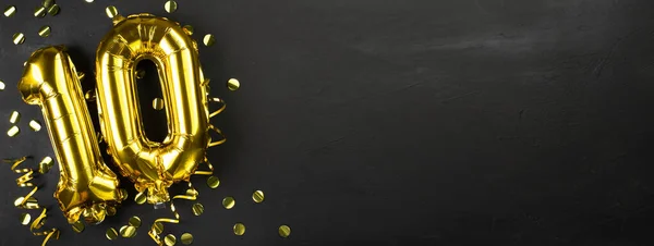 10 ya da 10 numaralı altın folyo balonu. Onuncu yazıda yazılı doğum günü tebrik kartı. Siyah beton arka plan. Yıldönümünü kutluyoruz. Pankart. Boşluğu kopyala