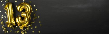 13 numaralı altın folyo balonu. 13. yazılı doğum günü veya yıldönümü tebrik kartı. Siyah beton arka plan. Yıldönümü kutlaması. Pankart. Boşluğu kopyala