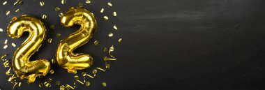 Altın folyo balonu 22 numara. Doğum günü ya da yıldönümü tebrik kartı. Üzerinde 22 yazılıydı. Siyah beton arka plan. Yıldönümü kutlaması. Pankart. Boşluğu kopyala