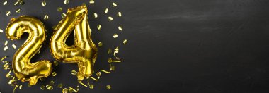 24 numaralı altın folyo balonu. 24 yazılı doğum günü ya da yıldönümü tebrik kartı. Siyah beton arka plan. Yıldönümü kutlaması. Pankart. Boşluğu kopyala