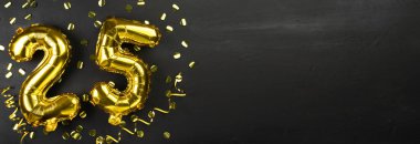 Altın folyo balonu 25 numara. 25 yazılı doğum günü ya da yıldönümü tebrik kartı. Siyah beton arka plan. Yıldönümü kutlaması. Pankart. Boşluğu kopyala
