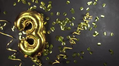 Altın folyo balonu, üç ya da üç numara. 3. Yazılı doğum günü tebrik kartı. Siyah beton arka plan. Yıldönümünü kutluyoruz..