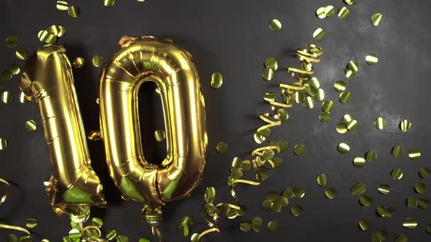 Zlatý balónek číslo deset nebo deset. Narozeninové přání s nápisem 10. černý betonový podklad. Slavíme výročí.. — Stock video
