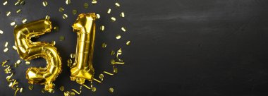 Altın folyo balonu 51 numara. 51 yazılı doğum günü ya da yıldönümü kartı. Siyah beton arka plan. Yıldönümü kutlaması. Pankart. Boşluğu kopyala