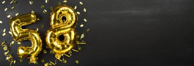 Elli sekiz numaralı altın folyo balonu. 58 yazılı doğum günü ya da yıldönümü kartı. Siyah beton arka plan. Yıldönümü kutlaması. Pankart. Boşluğu kopyala