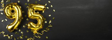 95 numaralı altın folyo balonu. 95 yazılı doğum günü ya da yıldönümü kartı. Siyah beton arka plan. Yıldönümü kutlaması. Pankart. Boşluğu kopyala
