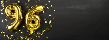 96 numaralı altın folyo balonu. Doğum günü ya da yıldönümü kartında 96 yazılıydı. Siyah beton arka plan. Yıldönümü kutlaması. Pankart. Boşluğu kopyala