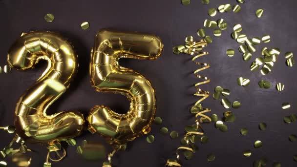 Globo dorada número veinticinco. Tarjeta de felicitación de cumpleaños o aniversario con la inscripción 25. Fondo de hormigón negro. Celebración del aniversario. . — Vídeo de stock