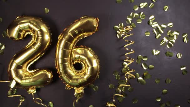 Ballon en feuille d'or numéro 26. Carte de vœux d'anniversaire avec inscription 26. Fond en béton noir. Fête anniversaire. — Video