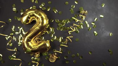 İki ya da iki numaralı altın folyo balonu. Üzerinde ikinci siyah beton yazı olan doğum günü tebrik kartı. Yıldönümünü kutluyoruz..