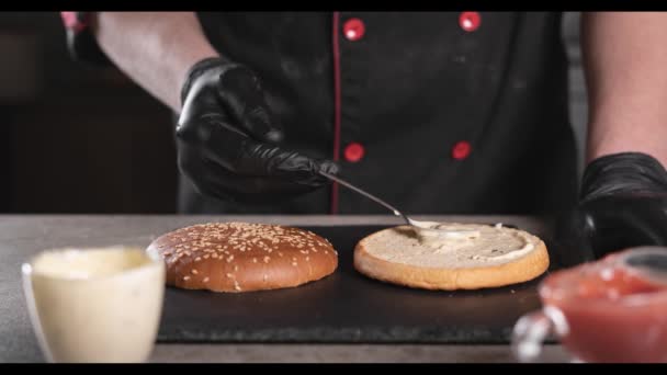 Proces výroby a výroby hamburgerů rukou šéfkuchaře mužského pohlaví. Přísady hamburgerů. Zastavit pohyb. — Stock video