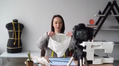 Kendine güvenen iş kadını vlogger kamerayla konuşuyor canlı iş vlog konsepti, beyaz kadın iç çamaşırı kalitesi üzerine video eleştirisi yapıyor..