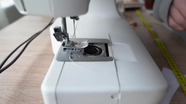 The seamstress replaces the bobbin in the sewing machine, close-up of female hands with manicure. small business concept. — Stock Video