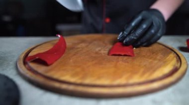 Mutfak şefinin yakın plan çekimi kırmızı dolmalık biberi kesiyor. Restoranların mutfağında yemek malzemesi olarak hazırlanacak. Kırmızı dolmalık biberi beyaz kesim tahtasında kesecek..