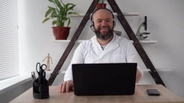 Video konferansı ve zoom 'da beyaz bir doktor. Pratisyen hekimler ve psikologlar için online webinar. Sorunun çözümü. Çalışan öğrenim görüyor ve ağda çalışıyor. Elektronik aygıt kullanıcısı
