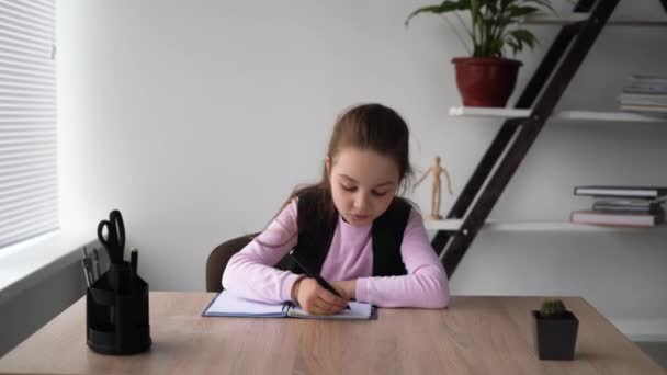 Serious schoolmeisje 7s tiener doet haar wiskunde docenten huiswerk door het opschrijven van de oplossing in een werkboek. Problemen van thuis onderwijs op uw eigen. Begrip basisschoolleerlingen. — Stockvideo