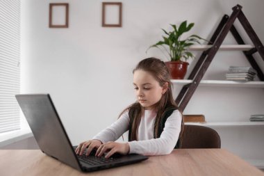 İnternet bağımlısı liseli kız bir dizüstü bilgisayarın başına oturmuş mesaj yazıyor ya da internet üzerinden bir ağ oyunu oynuyor. Modern zeki öğrencilerin bağımlılık problemi. Eğitim dersi video iletişimi.