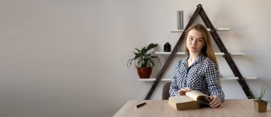 Ciddi yabancı dil öğretmeni kız öğretmen ofiste bir ders kitabıyla oturur ve uzaktan çalışır. Ev ödevi yapan kız öğrenci. Çalışma ve çalışma mesafesi kavramı.