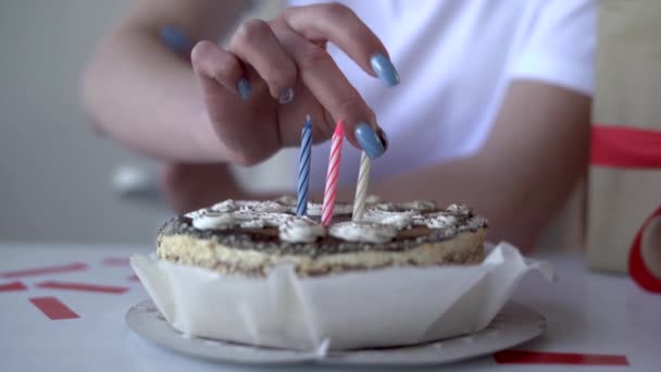 Närbild av kvinnliga händer sticker ljus i en födelsedagstårta. Utan ansikte. — Stockvideo