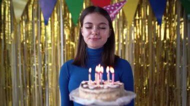 Bir doğum günü partisinde elinde pastayla beyaz bir bayan dilek diliyor ve yanan mumları söndürüyor. Uzaktan kumandalı bir çöl tatili. Kızlar için parti konsepti..