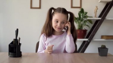 Kız, annesiyle cep telefonuyla konuşuyor. Cep telefonundan konuşan bir kız. Çocukça bir hayat ve arkadaşlarla bir bağ. Okul danışmanlığı.