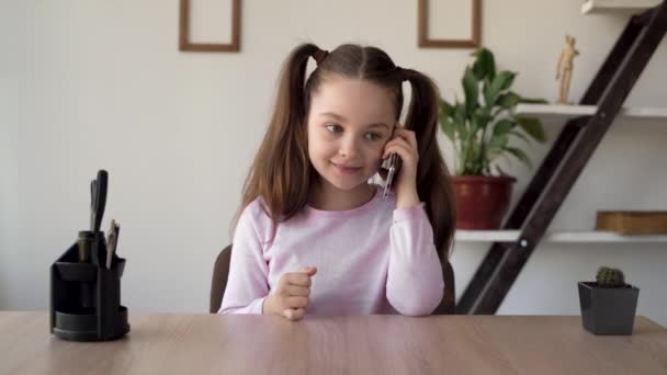 La hija está hablando con su madre en su teléfono celular. Chica hablando en el móvil. Gadgets en una vida infantil y la conexión con los amigos. Consulta escolar. — Vídeos de Stock