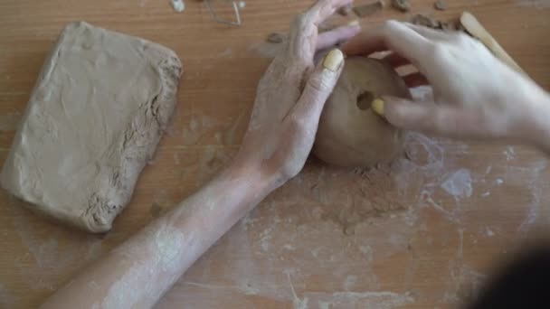 Fáze vytváření hrnce z hlíny. Ženské ruce dělají díru do kusu hlíny. řemeslná práce a kreativní řemeslná koncepce. — Stock video