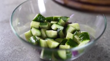 Erkek eller bir kase doğranmış salatalığa kirazlı domates koyar. Adım adım ev yapımı salata tarifi..