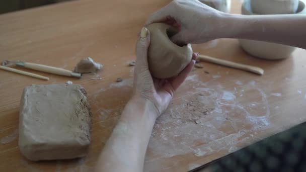 Workshop de modelagem de argila. Passatempo feito à mão. Uma jovem escultora esculpe um vaso de barro com as mãos. trabalho artesanal e conceito de artesanato criativo. — Vídeo de Stock