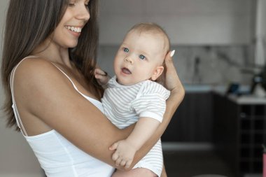 Genç, güzel, beyaz bir anne oğlunu kollarına aldı ve ona baktı..
