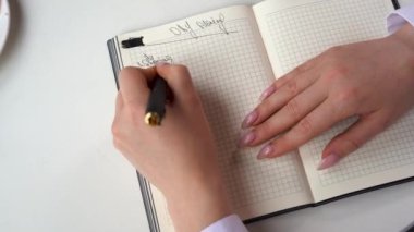 Not defterine yapılacaklar listesi yazan bir kadının el resmi. İş kadını için plan yapıyorum. Kız organizatörde notlar alıyor. Zamanla planlama ve çalışma kavramı.