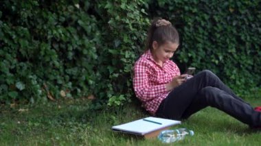 Genç bir kız parkta cep telefonu kullanıyor, sevimli bir genç resim çekiyor ya da üniversitede molada açık alanlarda Wi-Fi ile modern bir cihazda video izliyor..