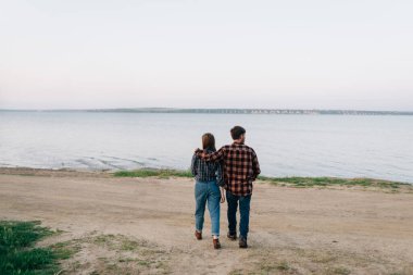Kucaklaşan genç bir aile, deniz kıyısına ekose gömleklerle gider, deniz kenarında yürür. Bir adam ve bir kız adada dolaşıyorlar. Turizm ve seyahat kavramı ilkbahar ya da sonbaharda.