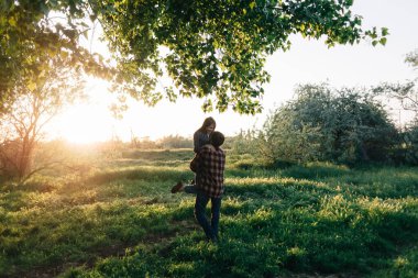 Ormanda gün ışığında sevgilisini kucağında büyütür. Gündelik giysiler içinde evli bir çift doğada dinlenir. Güzel öğrenciler seyahat ederken sarılır.