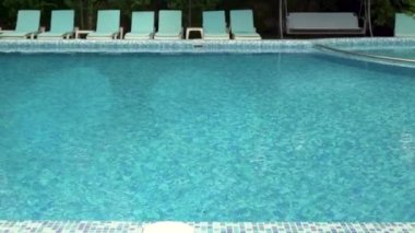 Otelde güneşli havuzun manzarası var. Deniz arkaplanı.