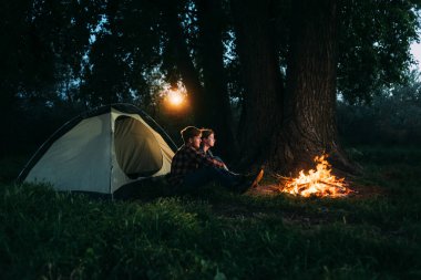 Genç bir çift turist kamp ateşi yakıyor ve gün batımında çadırın yanındaki ormanda oturuyorlar. Akşamları bir erkek ve bir kızın profiline bakılıyor. Kamp öğrencilerinin dinlenmek için boş yerleri var.