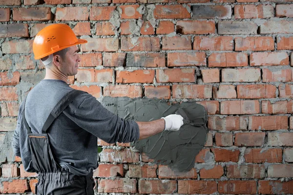 시멘트 모르타르를 바르는 보호용 헬멧을 건축가 관리자는 건물을 완성하는 종사하고 — 스톡 사진