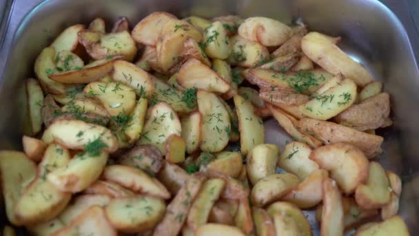 Potatoes cooked in a country style close-up with dill. A large spoon is used to pick up food in the dining room or buffet. — Stock Video