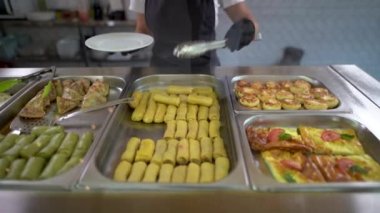 Okul kafeteryasında ya da yemek sırasındaki büfede, hizmetliler yiyecekleri süzme peynirli bir gözleme tabağına koydular. Tatlı nefis..