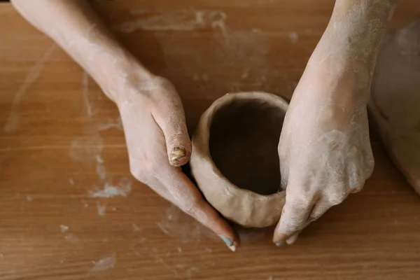 Top view of female hands sculpt utensils from clay. — Zdjęcie stockowe