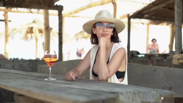 Female hand with a glass of Cuba Libre cocktail on a tropical beach. Summer resort concept, alcoholic drinks. Caucasian lady resting during vacation. — Stock Video