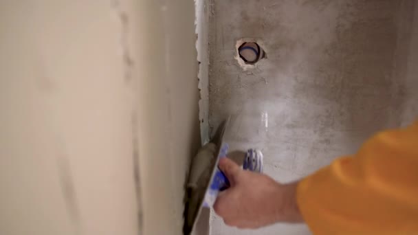 Renovasi dinding. Plastering dinding. Menerapkan putty atau tile adhesive ke dinding. Plastering dinding dengan spatula. Konstruksi internal dan penyelesaian karya. — Stok Video