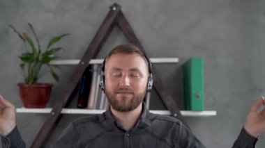 Beyaz sakallı adam ofiste gözleri kapalı oturur ve çalışırken nilüfer çiçeği pozisyonunda meditasyon yapar. Buruşmuş kağıtlar masanın üzerine saçılmış. Kendine karşı soğukkanlılık ve birlik