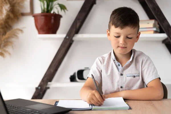 Close Elementary School Student Writes Homework While Studying Online Using — Fotografia de Stock